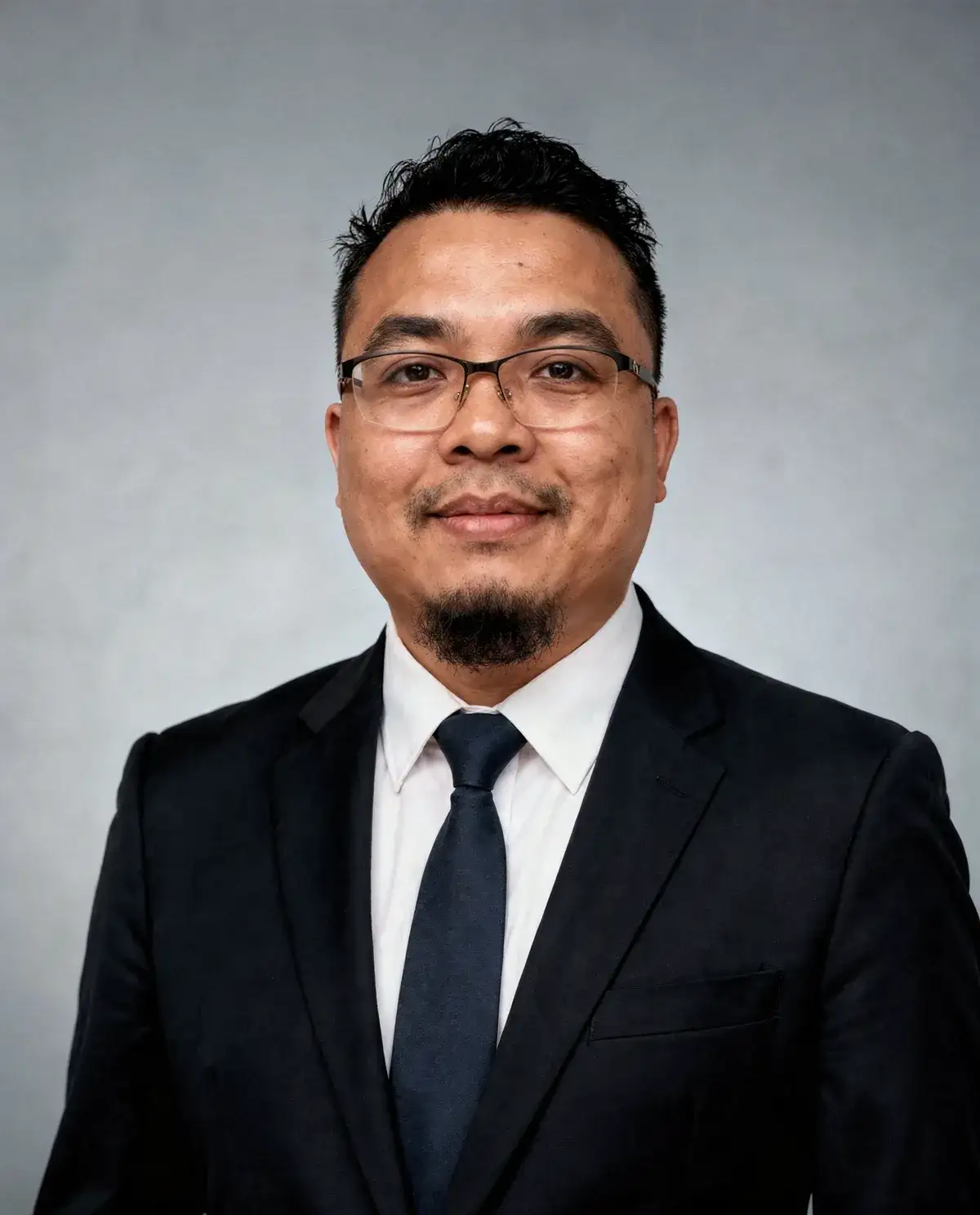 Saif Muhtar in a dark suit, studio portrait